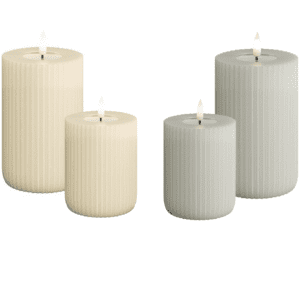 Zwei Sets LED Echtwachskerzen - Riffel, eines in Creme und eines in Grau, sind vor einem weißen Hintergrund abgebildet. Beide Sets enthalten eine hohe und eine niedrige Kerze mit sanft flackernden Flammen.
