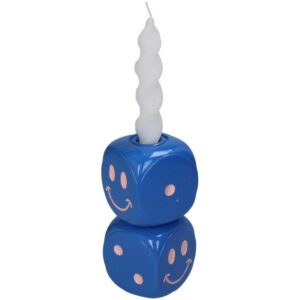 Eine weiße Spiralkerze sitzt in einem Kerzenhalter-Würfel, der aus zwei gestapelten blauen Würfeln besteht, die mit rosa Smileys verziert sind.