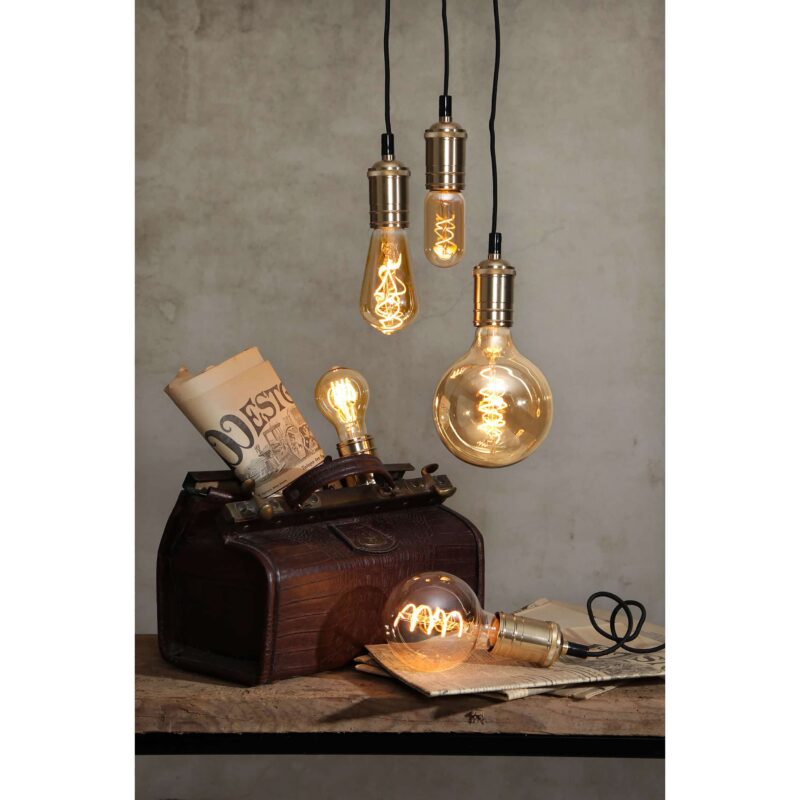 Eine Vielzahl von LED-Kolbenbirnen 3,2 W 2100 K Amber dimmbar Ø6,4 cm, angeordnet auf einer Holzoberfläche, ergänzen einen alten Koffer, eine zusammengerollte Karte und dekorative Papiere und schaffen eine nostalgische Atmosphäre.