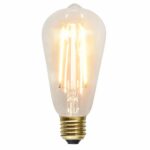 Die LED Kolben 3,6W 2100K Ø6,4cm von Licht Factory ist im Stil einer Vintage-Edison-Glühbirne gehalten. Sie hat einen sichtbaren Glühfaden in einem Gehäuse aus klarem Glas, ist mit einem Schraubsockel ausgestattet und strahlt warmes, weiches Licht aus, das eine einladende Atmosphäre schafft.