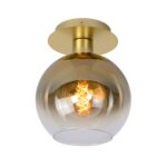 Die Deckenleuchte - Elly von Licht Factory verfügt über einen runden, klaren Glasschirm, in dem sich eine aufwendig gedrehte Glühlampe befindet. Der Sockel der Leuchte ist elegant in glattem Metallic-Gold gehalten.