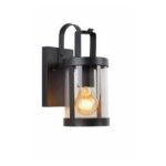 Die Licht Factory stellt die Außenleuchte - Lara vor, eine wandmontierte Außenlaterne mit schwarzem Metallrahmen und transparentem zylindrischem Glasgehäuse. Sie präsentiert elegant eine leuchtende Glühlampe mit einem stilvollen, geschwungenen Griffdesign oben.
