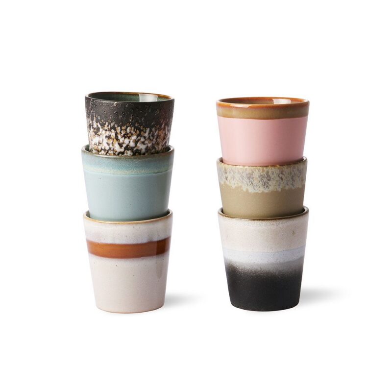 Zwei Stapel HK Living Kaffeebecher - Vintage Nature von Licht Factory; der linke Stapel weist dunkle Sprenkel, Mintgrün und Brauntöne auf, während der rechte Stapel Rosa und Beige mit Sprenkeln neben einer schwarzen Tasse mit Farbverlauf enthält.