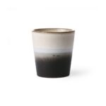 Der HK Living Kaffeebecher - Vintage Nature ist ein Keramikbecher mit minimalistischem Farbverlaufsdesign, das von hellbeige oben nach dunkelbraun unten übergeht. Er hat eine glatte Oberfläche und eine leicht konische Form.