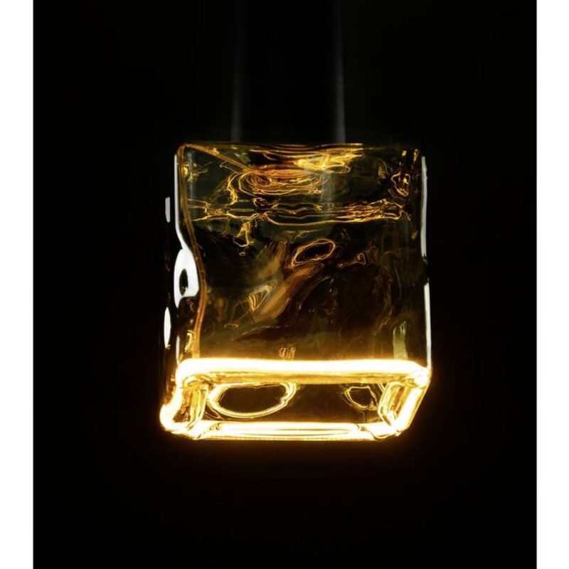 Ein leuchtendes Leuchtmittel Floatlight IceCube 6W dimmbar rauch 12,5cm hängt vor einem schwarzen Hintergrund und strahlt ein warmes, einladendes Licht aus. Seine strukturierte, reflektierende Oberfläche verleiht der Szene Tiefe und Eleganz.