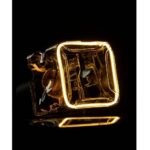Das Leuchtmittel - Floatlight IceCube 6 W dimmbar rauch 12,5 cm besteht aus einem beleuchteten Glaswürfel auf schwarzem Hintergrund mit leuchtenden Kanten, die einen beleuchteten Umriss erzeugen, der sich von der Dunkelheit abhebt, Reflexionen wirft und einen warmen, goldenen Farbton aufweist.