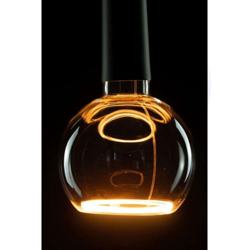 Eine Nahaufnahme des Leuchtmittels - Floatlight Globe 4W dimmbar gold Ø15cm zeigt sein beleuchtetes, kugelförmiges Glas mit einem leuchtenden Glühfaden im Inneren. Die Glühbirne strahlt vor einem dunklen Hintergrund ein warmes bernsteinfarbenes Licht aus und hebt so ihre reflektierende Oberfläche und moderne Eleganz hervor.