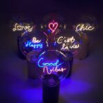 Die Statement-Glühbirne „Herz Pink“ erzeugt lebendige Farbtöne und lässt motivierende Worte wie „Liebe“, „Sei glücklich“ und „Gute Stimmung“ in den Farben Lila, Rosa, Blau und Gelb in schwach beleuchteten Umgebungen aufleuchten.