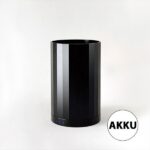 Ein schlankes, schwarzes, zylindrisches elektronisches Gerät mit drei blauen Lichtern an der Basis ruht elegant auf einem schlichten weißen Hintergrund. Das minimalistische Design weist auf „AKKU“ hin, was darauf hindeutet, dass es sich um einen innovativen AKKU Leuchtenfuß handelt – Statement Bulbs.