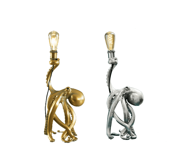 Zwei Tischleuchten - Oktopus-Lampen, eine goldene mit einer leuchtenden Vintage-Glühbirne und die andere silberne ohne Glühbirne, stehen nebeneinander. Ihre Tentakeln strecken sich elegant nach oben, um die Glühbirnen zu stützen.