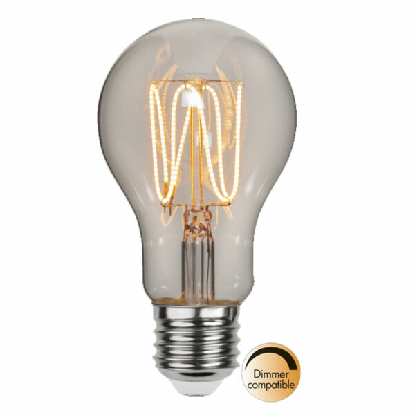 Eine klare dimmbare LED-Glühbirne mit 3,8 W und 1800 K Leuchtmittel - Tropfen verfügt über ein sichtbares Glühfadendesign, das ein warmes Licht ausstrahlt. Ihr metallischer Sockel verleiht ihr Eleganz, ergänzt durch ein „Dimmer-kompatibel“-Emblem in einem Farbverlauf aus Gold und Schwarz, das ihren Premium-Stil und ihre Vielseitigkeit hervorhebt.