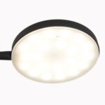 Nahaufnahme der runden, schwarzen Stehleuchte - Aike vor weißem Hintergrund. Das LED-Licht ist eingeschaltet und strahlt ein helles, gleichmäßiges Licht aus.