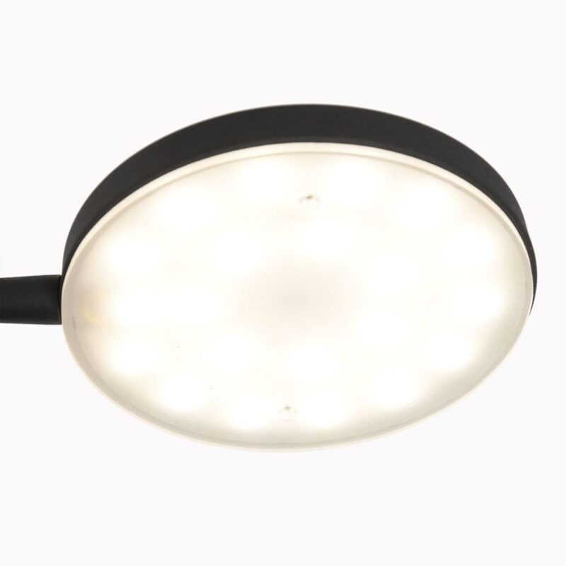 Nahaufnahme der runden, schwarzen Stehleuchte - Aike vor weißem Hintergrund. Das LED-Licht ist eingeschaltet und strahlt ein helles, gleichmäßiges Licht aus.