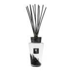 Der Baobab Diffuser – Platinum ist eine elegante Glasflasche mit schwarzen Stäbchen obenauf und einem schwarz-weißen Etikett mit dekorativem Baobab-Design und eleganten schwarzen Ornamenten, die durch den transparenten Boden sichtbar sind.