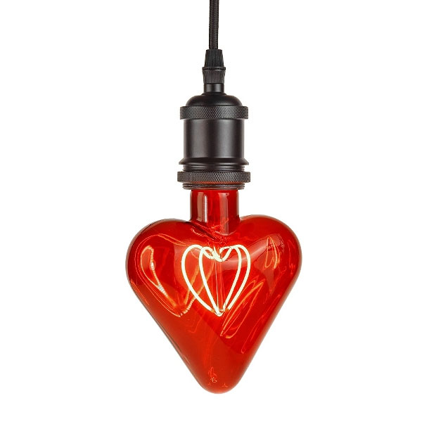 Das Leuchtmittel „Red Heart“ ist eine glänzende, rote, herzförmige Glühbirne mit einem leuchtenden Glühfaden, die an einem schwarzen Kabel hängt und eine warme und gemütliche Atmosphäre schafft.