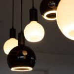 Nahaufnahme der LED-Pendelleuchten „Billard“ von Licht Factory mit kugelförmigen schwarz-weißen Designs. Die leuchtenden Glühbirnen strahlen ein warmes Licht aus, dessen sanft verschwommenen Hintergrund die zeitgenössische Ästhetik der Leuchten unterstreicht.