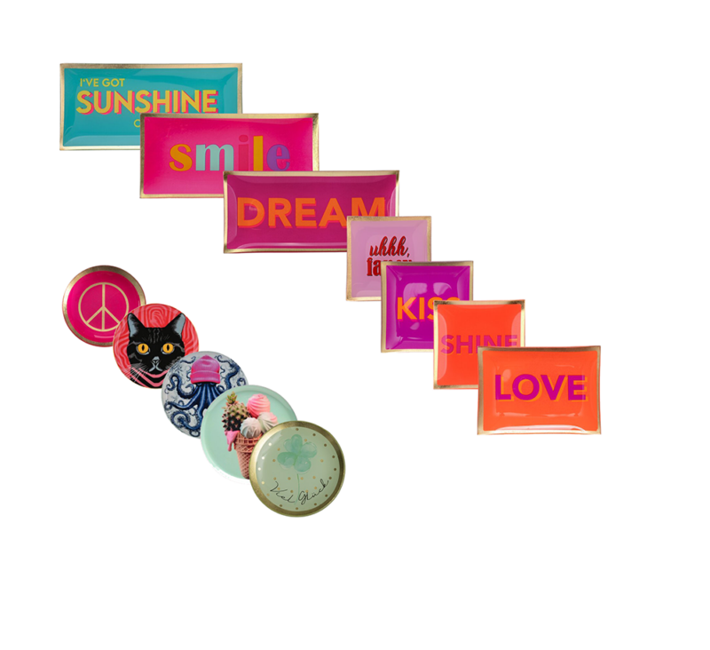 Neun bunte Servierplatten sind diagonal angeordnet. Auf den rechteckigen Platten sind „Ive Got Sunshine“, „Smile“, „Dream“, „Kiss“ und „Love“ zu sehen. Auf den runden Platten sind ein Peace-Zeichen, eine Katze, ein Oktopus, ein Vogel und der Text „La Vie est Belle“ zu sehen.
