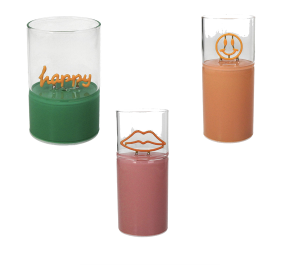 Das LED-Glas-Set enthält drei Kerzen: eine grüne mit „Happy“ in goldener Schrift, eine rosa mit goldenen Lippen und eine orange mit einem goldenen Smiley. An jeder Kerze ist das Symbol innen in der Nähe des Dochts angebracht. Verfügbar ab Woche 1, 2025.