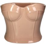 Die Vase - Mode von Licht Factory ist ein beigefarbener Keramiktopf in Form eines Korsetts oder trägerlosen Oberteils mit detaillierten Brust- und Taillenkonturen. Seine glänzende Oberfläche reflektiert das Licht und betont sein skulpturales Design.