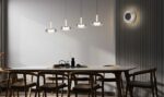 a dining table with chairs and a table with a group of lights from it