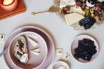 ein gut gedeckter Tisch mit pinken Geschirr und essen auf dem Tisch und auf den tellern