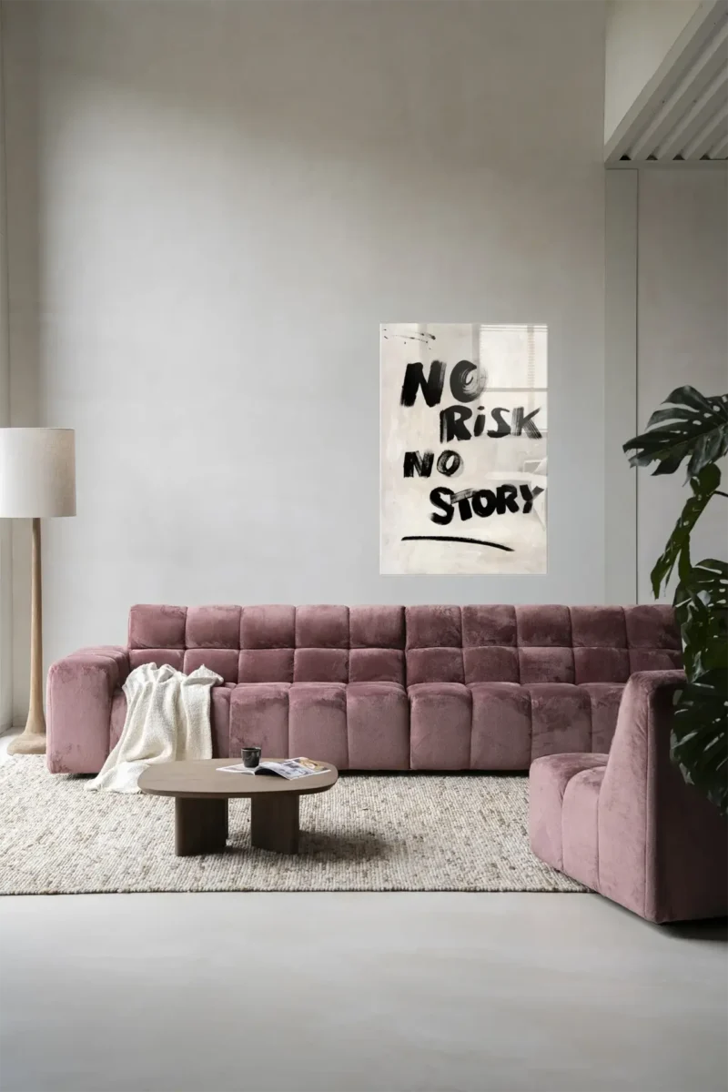 Ein modernes Wohnzimmer verfügt über ein großes malvenfarbenes Sofa, einen hölzernen Couchtisch und eine hohe Stehlampe. Ein Poster mit dem Titel „Wandbild – No Risk, No Story“ schmückt die Wand. Auf der rechten Seite ist teilweise eine Topfpflanze zu sehen, und alles steht vor einem hellgrauen Hintergrund.