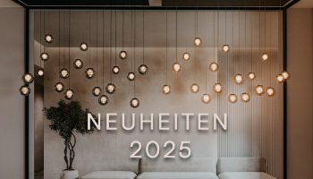Pendelleuchten mit einzelnen Glaspendel. Schriftzug Neuheiten 2025. Eine Couch sieht man auch noch.